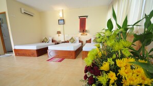 A hotel room with two beds, a large floral arrangement, and a red decorative wall hanging. - Dara Reang Sey Hotel Phnom Penh (Phnom Penh)