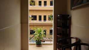 A narrow hallway with tiled flooring, a potted plant, and a wooden chair. - Dara Reang Sey Hotel Phnom Penh (Phnom Penh)