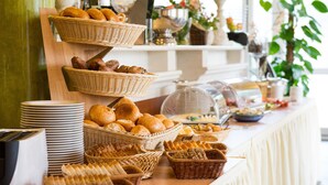 Une table de buffet proposant une variété de pains et de viennoiseries.
