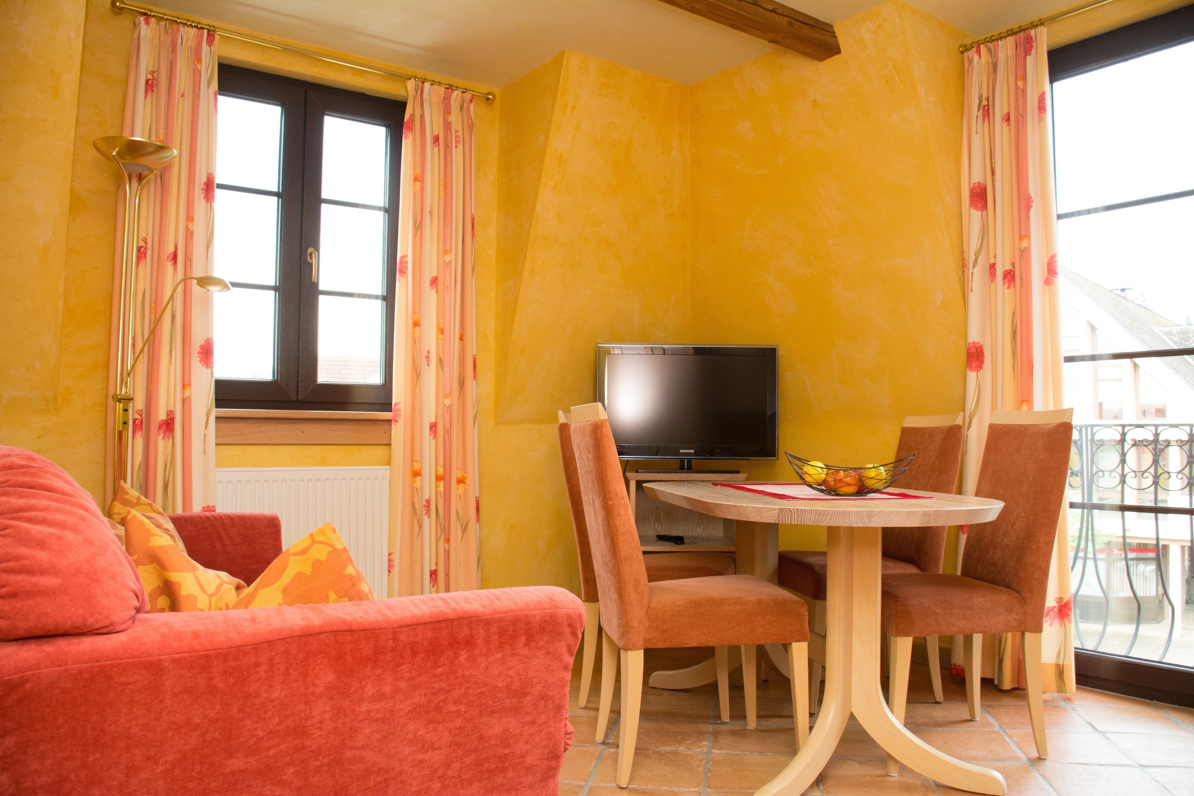 Une pièce confortable avec un téléviseur, une table à manger et des chaises.