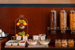 A breakfast buffet with various fruits, yogurt, and cereal options. - Hotel Aalders (Amsterdam)