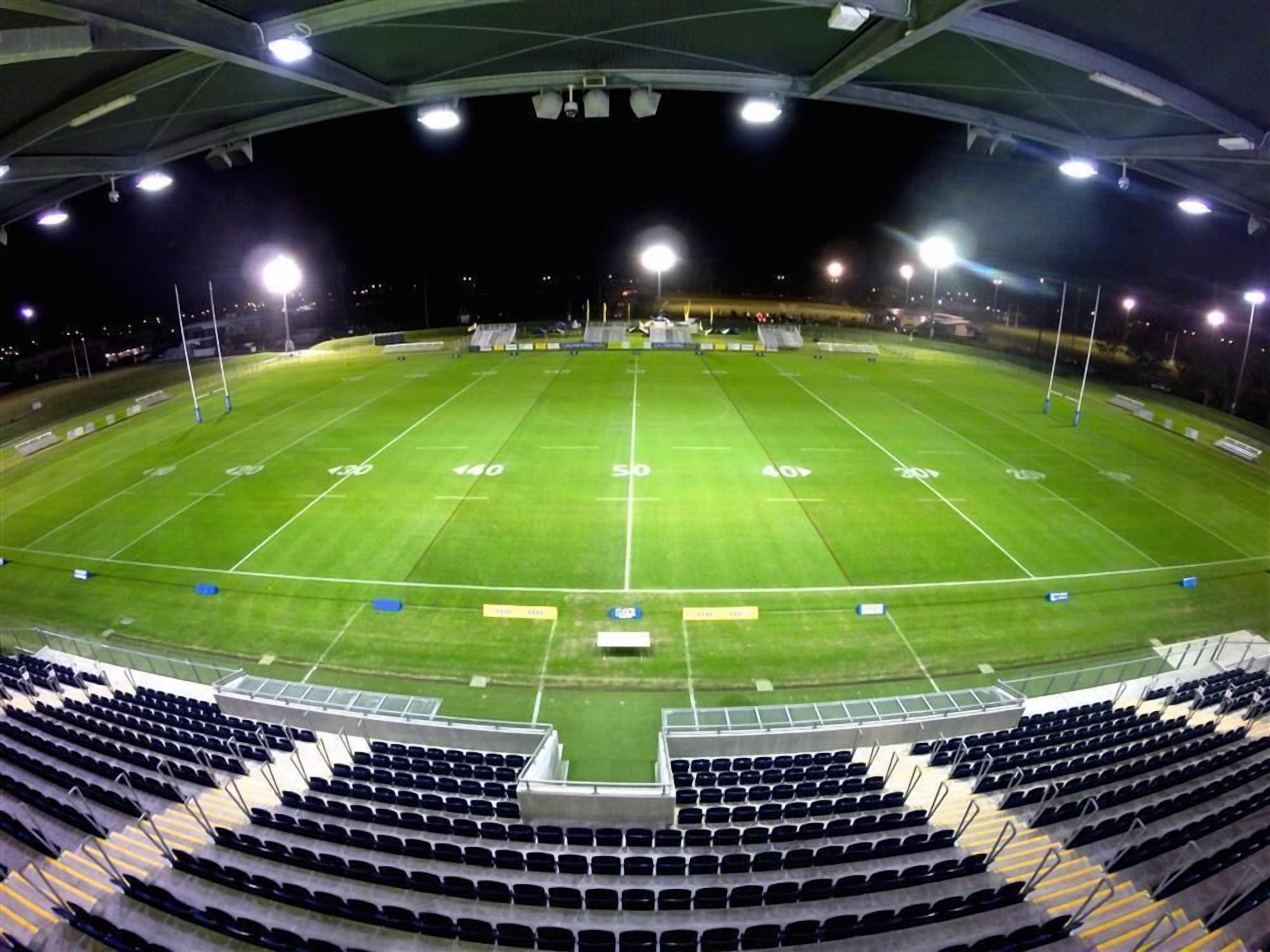 Un estadio de fútbol vacío con asientos en niveles y focos.