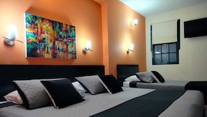 A hotel room with a large bed, two bedside tables, a painting on the wall, and a window with blinds. - Hotel La Herreria Colonial (Popayán)