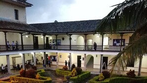 A courtyard with a fountain, neatly trimmed hedges, and a palm tree. - Hotel La Herreria Colonial (Popayán)