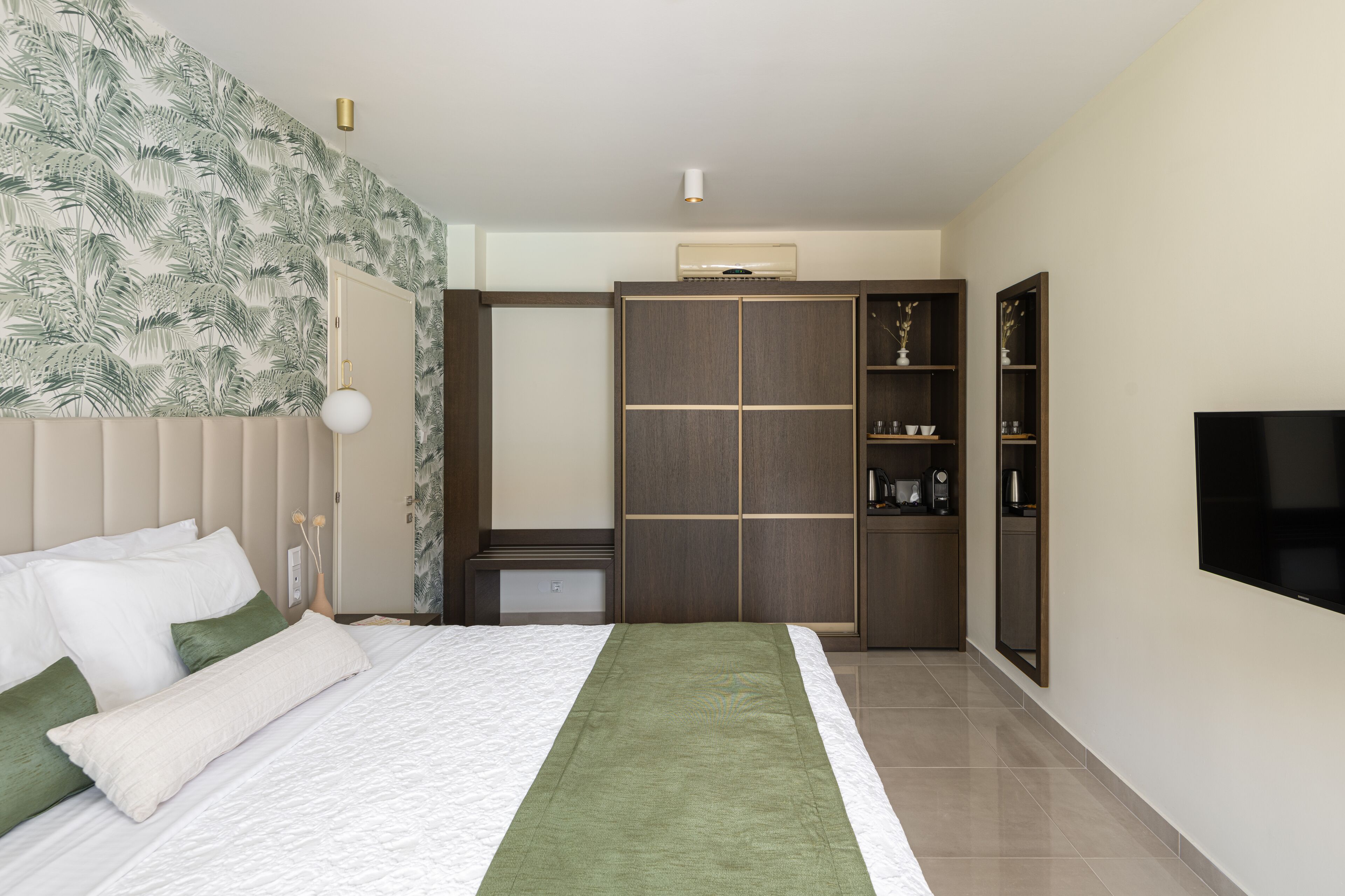 Une chambre à coucher avec un lit, une armoire, une télévision et un miroir.