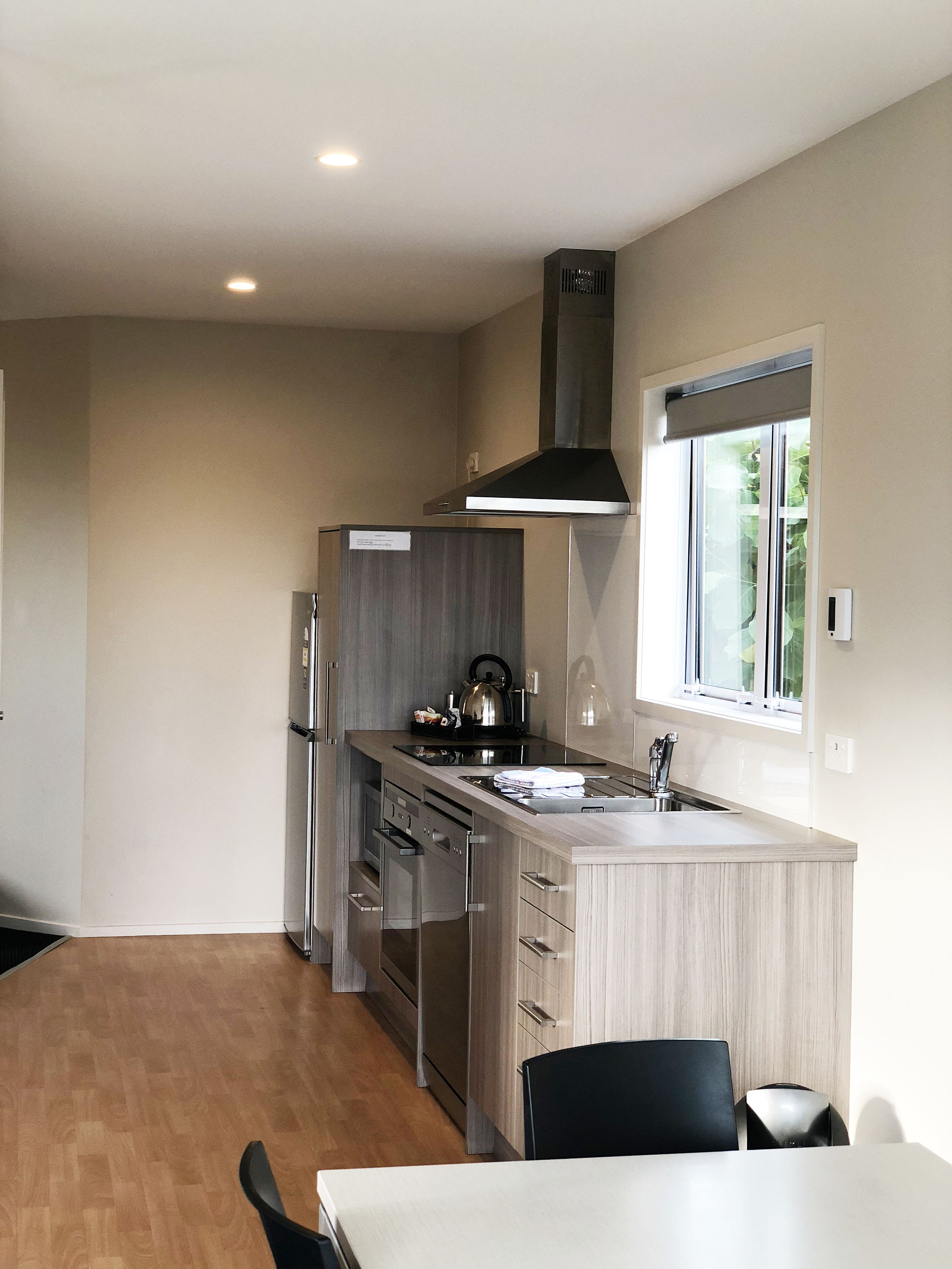 A modern kitchen with a central island, stainless steel appliances, and a window providing natural light.