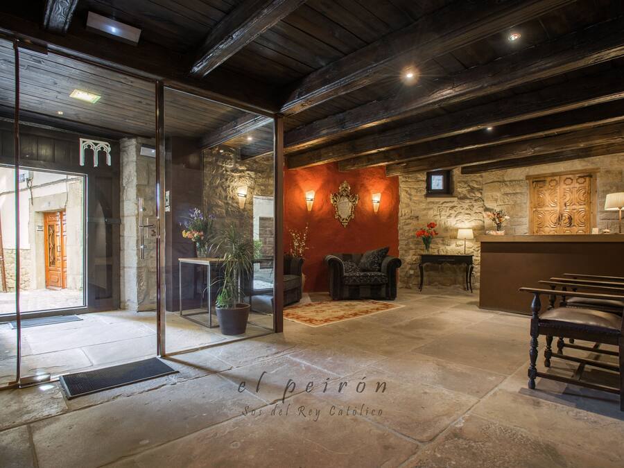 Eine Lobby mit Steinböden, Kamin, Sitzgruppe und einer Rezeption.