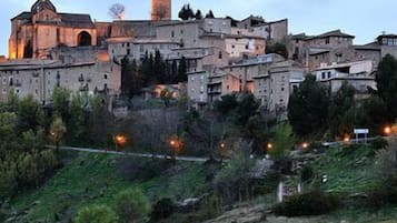 Un pueblo histórico con arquitectura medieval, incluyendo una torre destacada y una iglesia con campanario.