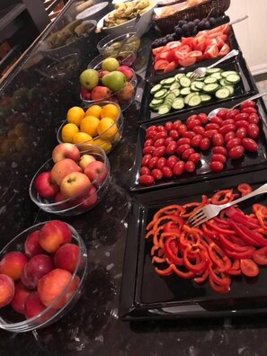 Un bufé con diversas frutas y verduras.