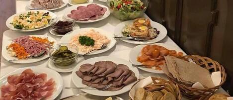 A buffet table with various food items including meats, cheeses, salads, and crackers.