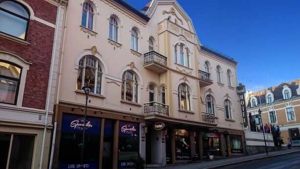 Ein historisches Gebäude mit mehreren Geschäften, darunter ein Hotel, eine Sportsbar und ein Restaurant.