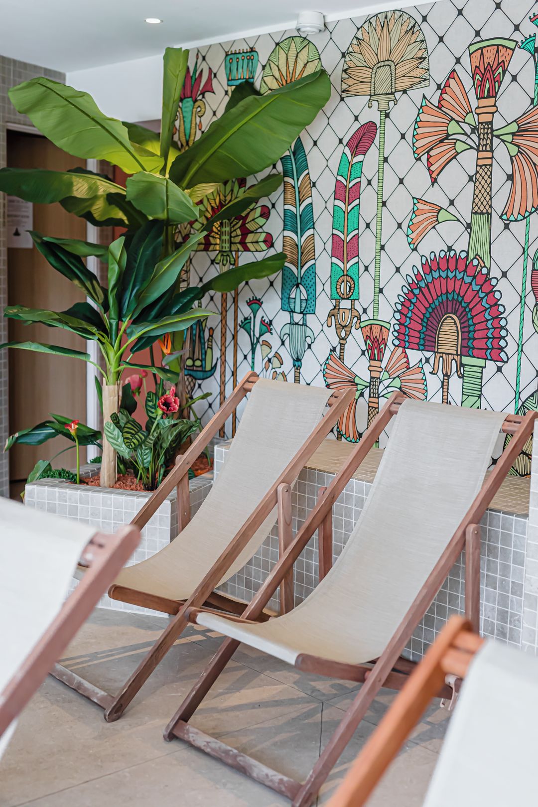 A poolside area with lounge chairs and a decorative wall mural.
