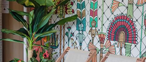 A poolside area with lounge chairs and a decorative wall mural.