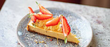 Un postre en un plato con un tenedor sobre la mesa.