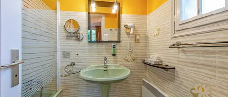 A bathroom with a green sink, a mirror, a towel rack, and a shower.