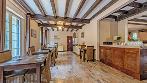 A spacious dining area with wooden tables and chairs, a marble floor, and exposed wooden beams on the ceiling. - Hotel De la Corniche (Brest)