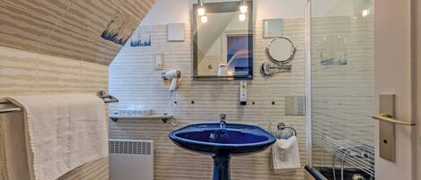 A bathroom with a blue sink, a mirror, and a towel rack.