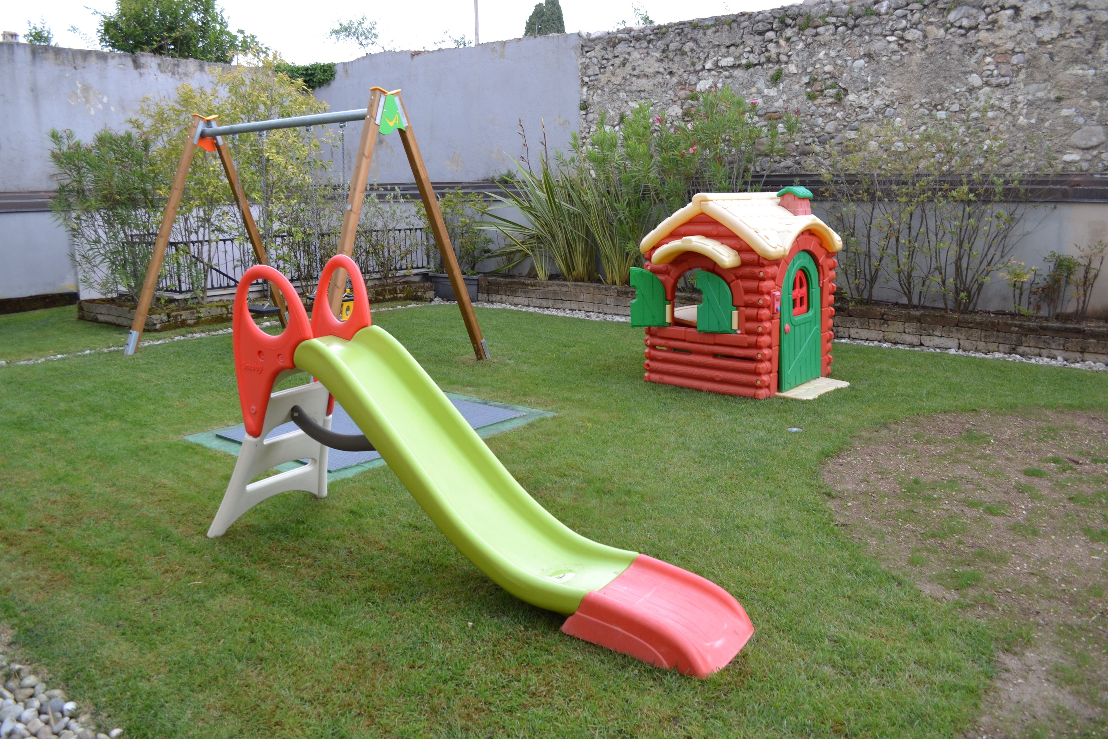 Un parque infantil con tobogán y columpios.