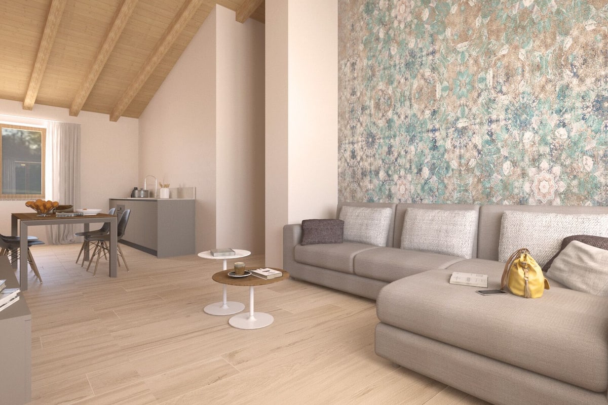 Una sala de estar moderna con un sofá gris, una mesita redonda y un comedor con una mesa de madera y sillas.