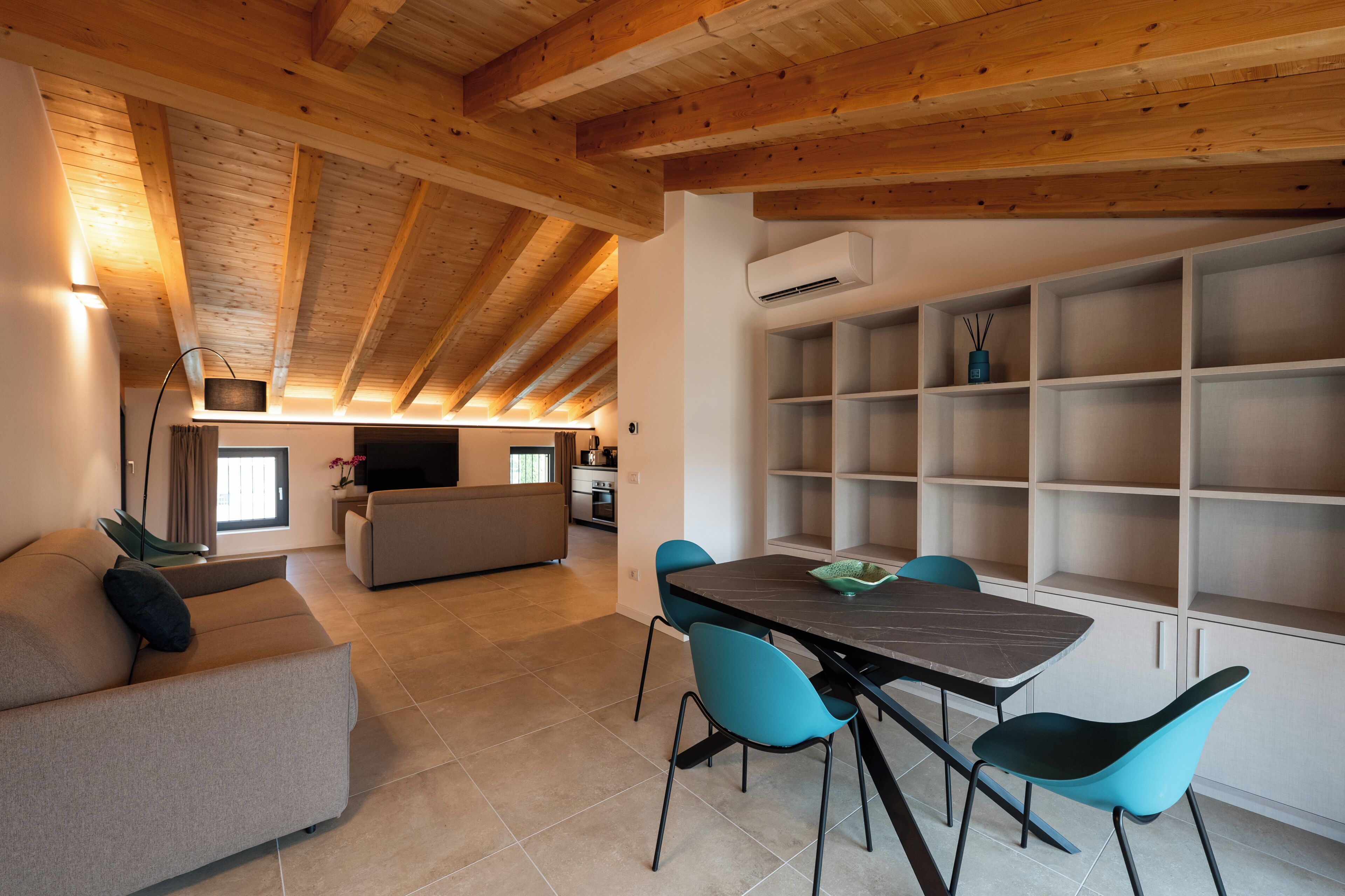 Een modern interieur met een eethoek, een bank en een keuken op de achtergrond.