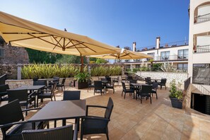 Relax in style on our outdoor patio, surrounded by lush greenery and comfortable seating.