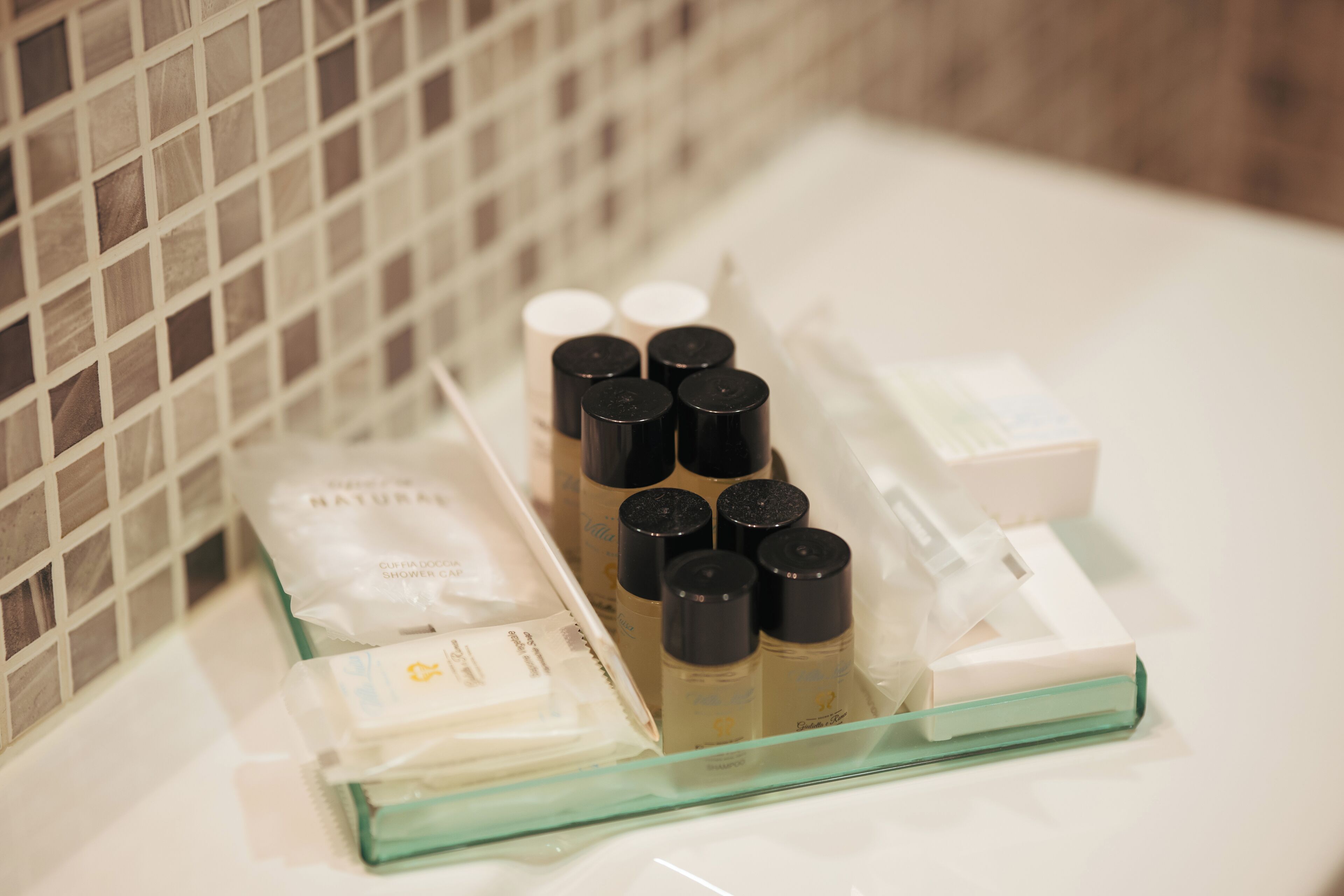 Ein Badezimmer mit Ablagefläche aus Glas für Pflegeprodukte und einem weißen Waschbecken.