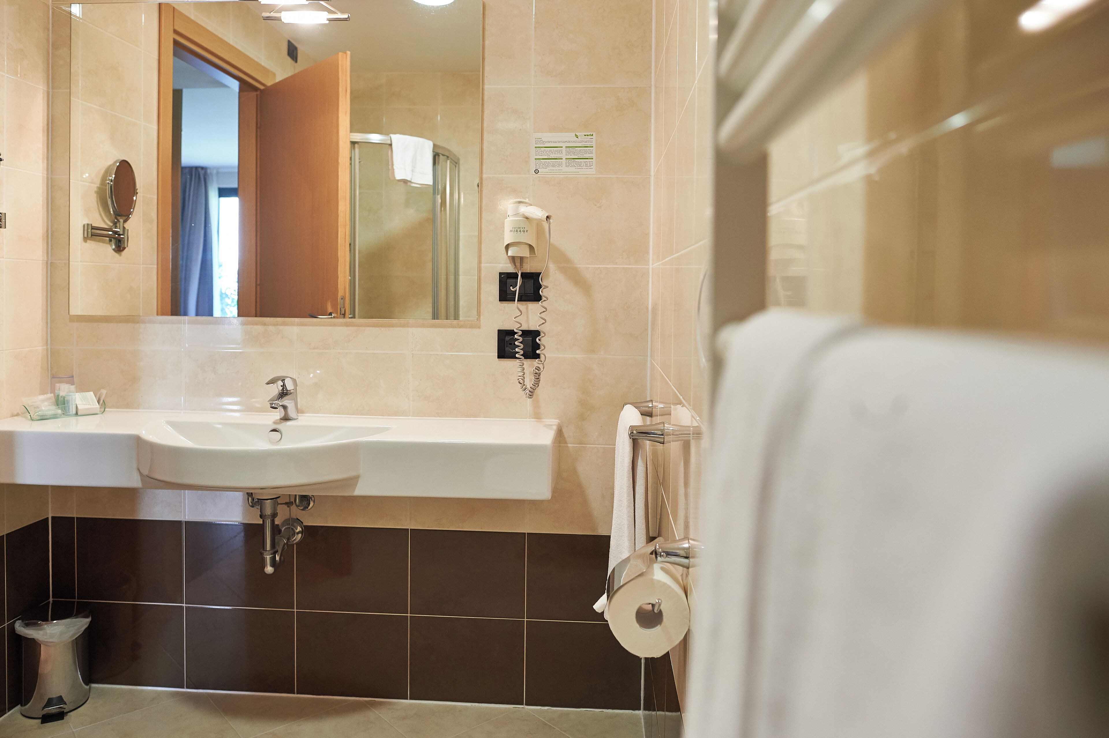 A bathroom with a sink, mirror, and towel rack.