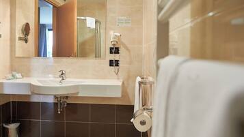 A bathroom with a sink, mirror, and towel rack.