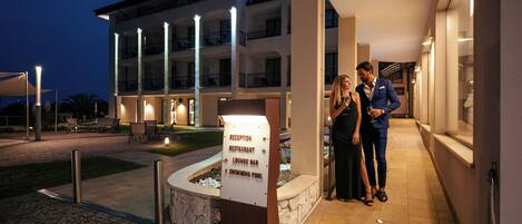 A reception area with a sign indicating amenities such as a restaurant, lounge bar, and swimming pool.