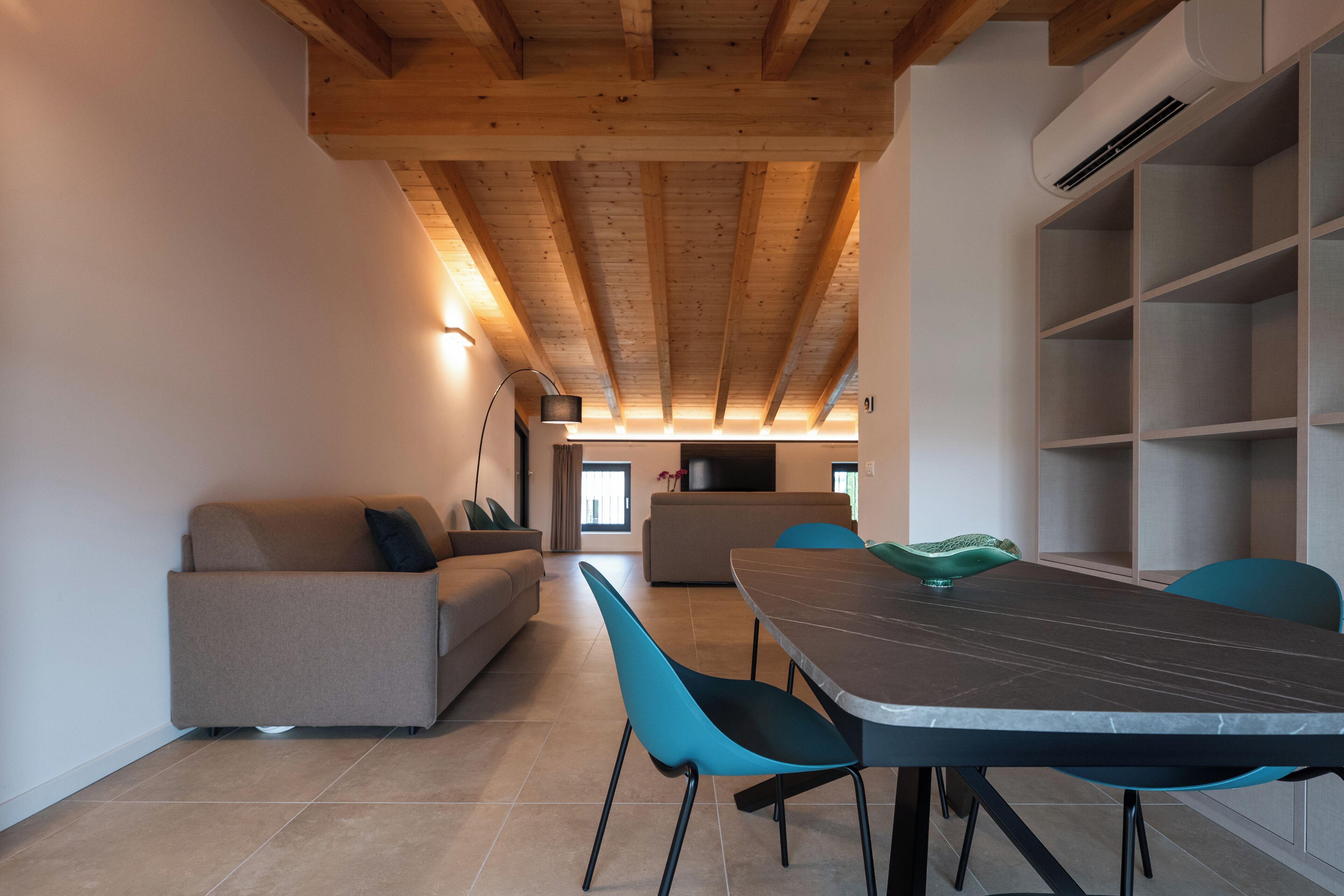 Un intérieur moderne avec un coin repas, un canapé et une cuisine en arrière-plan.
