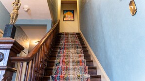 A staircase with a patterned carpet and a statue on the left. - The Maple Inn B&B (Parrsboro)