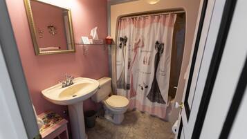 A bathroom with a sink, toilet, and shower curtain.