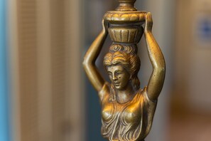 A close-up of a golden statue with a vase on its head.