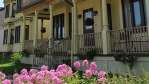 A two-story building with a balcony and a flagpole. - The Maple Inn B&B (Parrsboro)