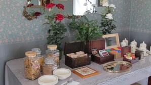 A dining table with a lace tablecloth, surrounded by various food items and condiments.