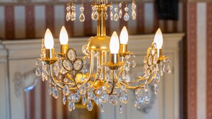 A chandelier with multiple arms and crystal decorations.