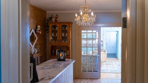 A kitchen with a marble countertop, wooden cabinets, and a chandelier. - The Maple Inn B&B (Parrsboro)