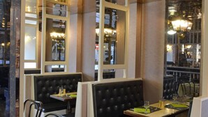 A restaurant interior with booth seating, tables, and a bar area. - Le Continental (Chateauroux)