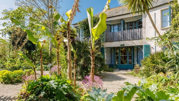 Un immeuble de deux étages avec un jardin à l’avant.