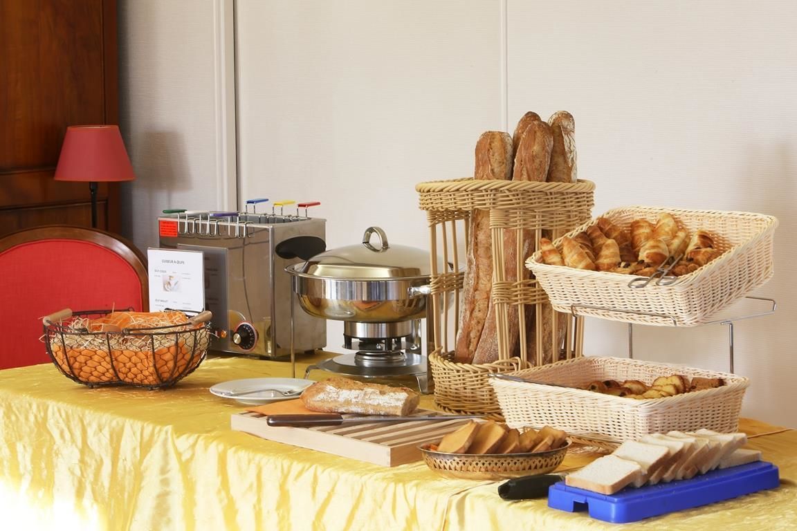 Une table de buffet proposant divers plats, notamment du pain et des pâtisseries, ainsi qu’un coin où l’on peut préparer des plats à la chinoise.