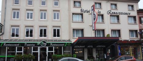 Un hotel llamado "Hotel la Renaissance" con una pizzería en la planta baja.