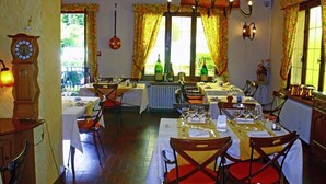 Un comedor con mesas dispuestas para comidas, un reloj y cortinas.