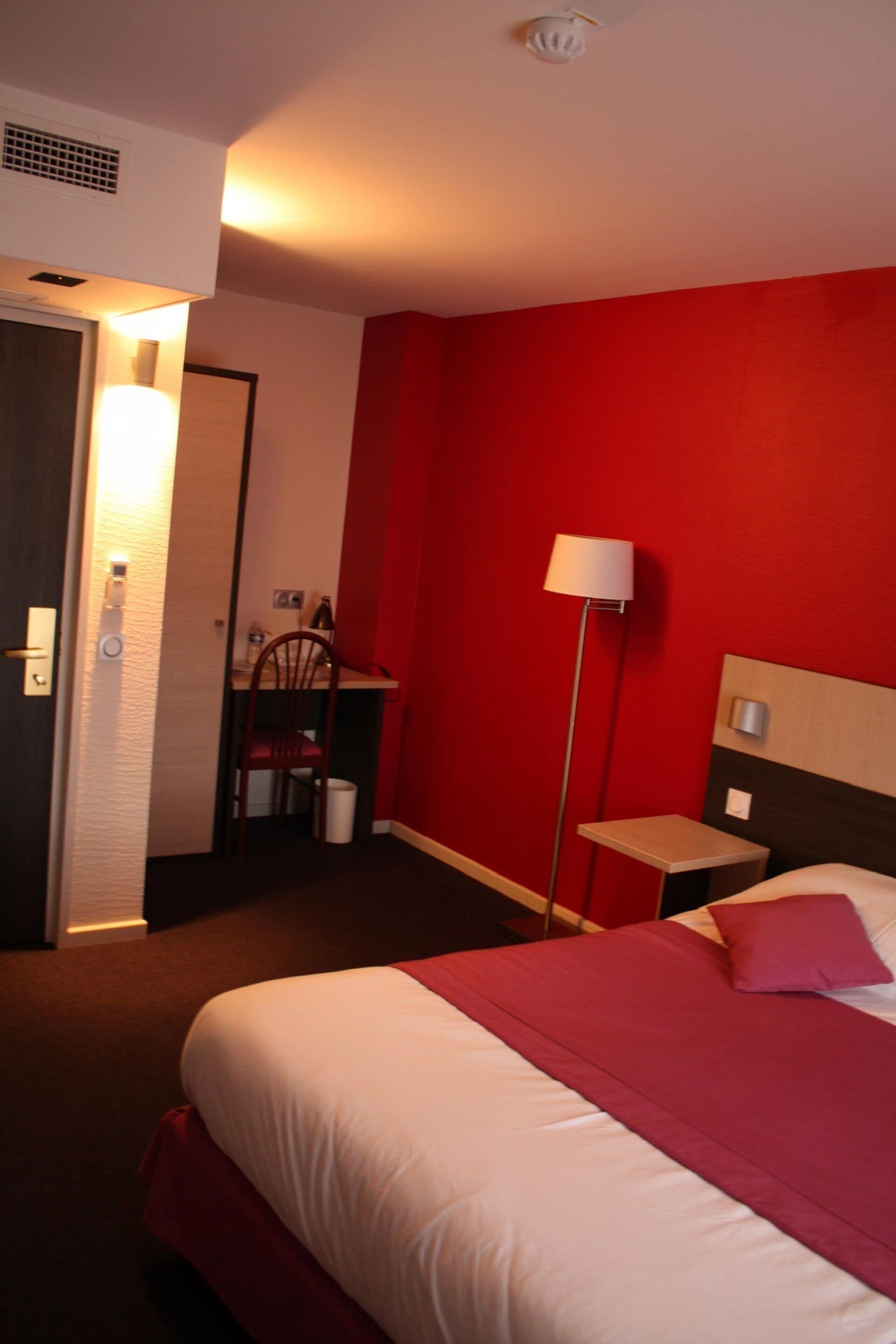 Una habitación de hotel con una cama, un escritorio y una silla.
