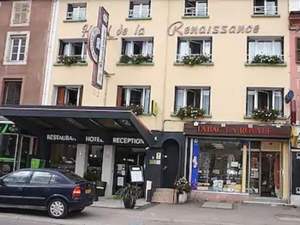 A hotel with a sign reading "Hotel de la Renaissance" and a "RESTAURANT" sign below.