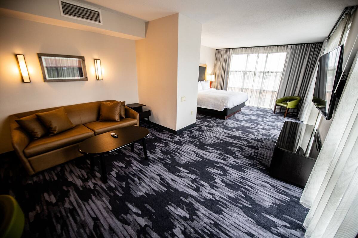 Une chambre d’hôtel avec un grand lit, un canapé, une table basse et un téléviseur.