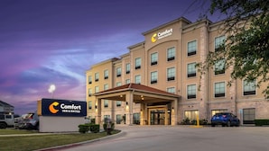 Un hotel Comfort Inn & Suites amb façana moderna, un vestíbul cobert i una zona d'aparcament.