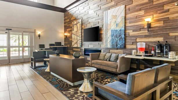 Eine moderne Hotellobby mit Rezeption, Sitzgelegenheiten und Kunstwerken an den Wänden.