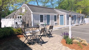 A small, single-story building with a porch and outdoor seating area. - Craigville Beach Inn (Centerville)