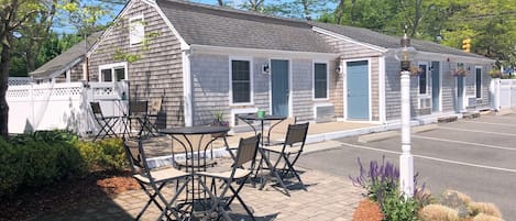 A small, single-story building with a porch and outdoor seating area.