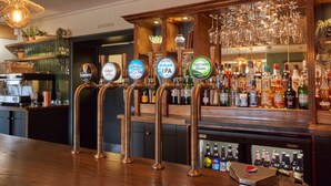 Un espace bar doté de nombreux robinets à bière et d’une grande variété de bouteilles d’alcool.